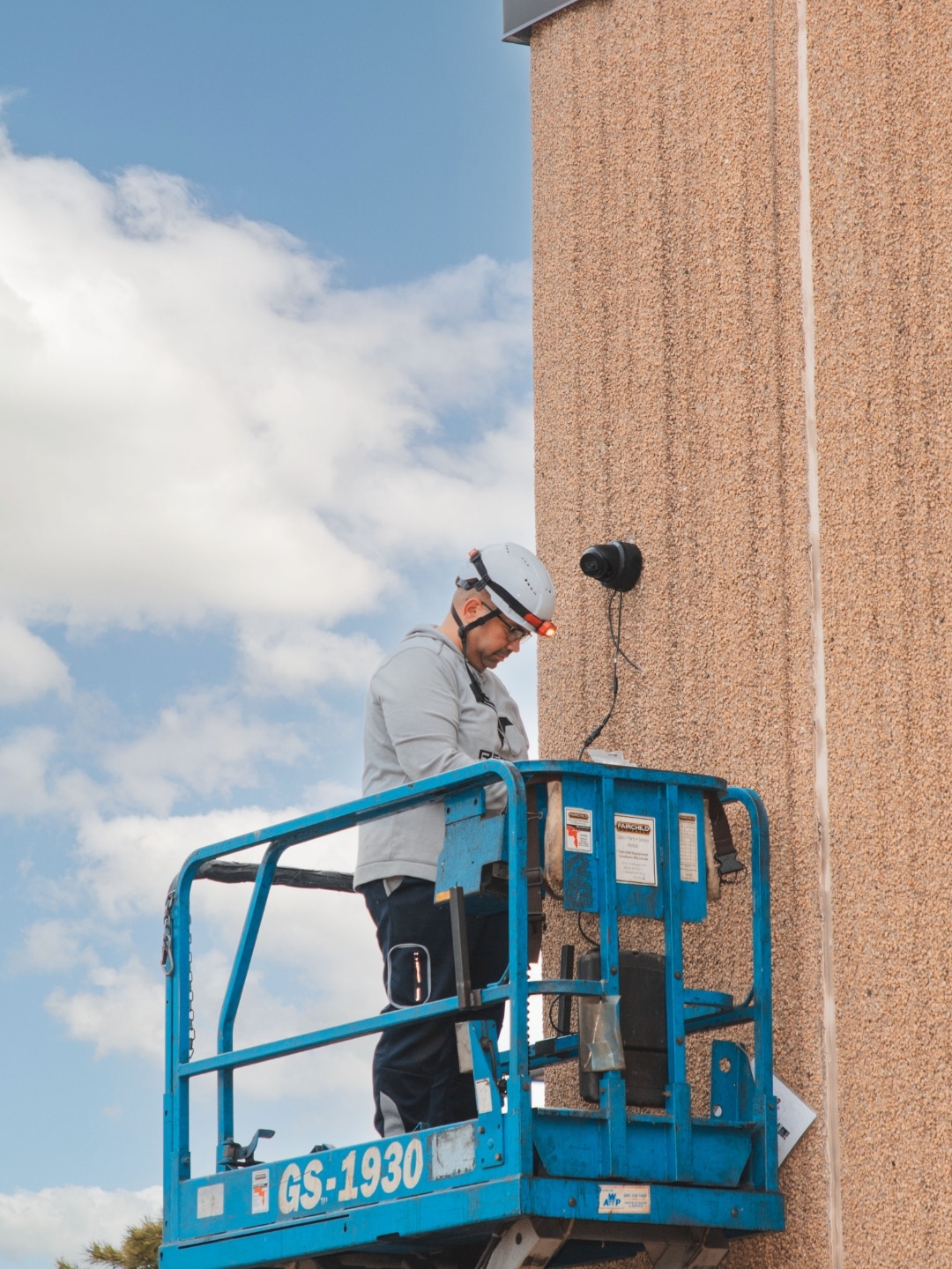 RedBird Technology Solutions technician installing a security camera on a lift inside a Milwaukee, Wisconsin commercial facility